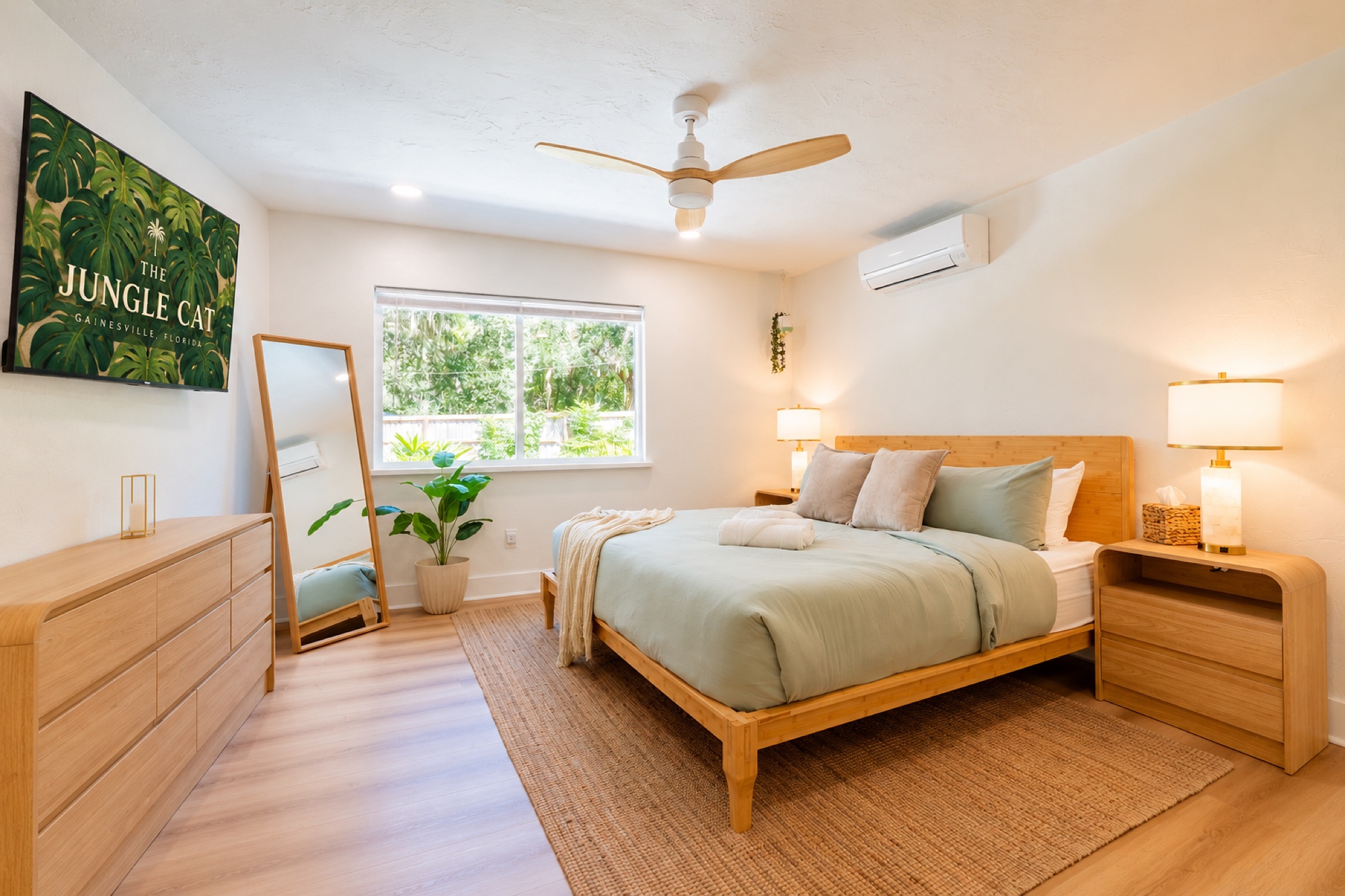 Bedroom with mirror and Jungle Cat sign on TV
